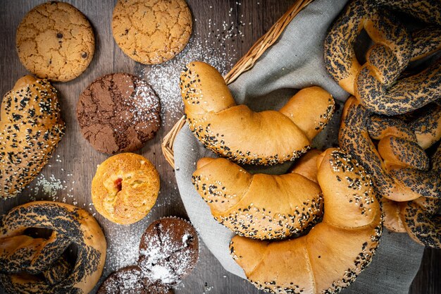 Pain et petits pains dans le panier en osier sur la vieille surface en bois