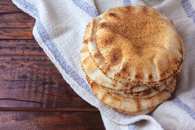 Pain pita isolé sur une table en bois rustique sur un chiffon rustique