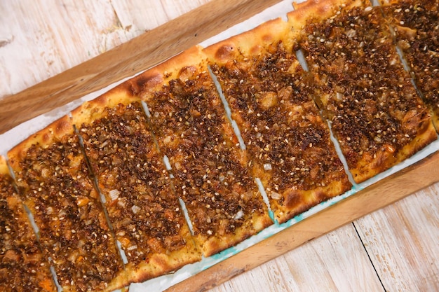 Pain de pizza Zaatar servi dans une planche de bois isolée sur fond vue de dessus du Manaqeesh arabe