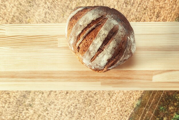 Pain sur une planche de bois sur le fond d'un champ de seigle vue de dessus