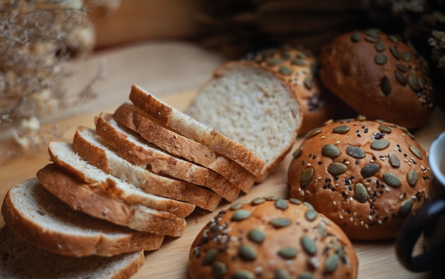 Pain sur une planche à découper en bois avec un panier de pain et une bouteille d'eau derrière