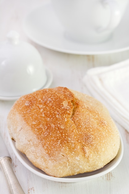 Pain sur plat blanc et tasse blanche