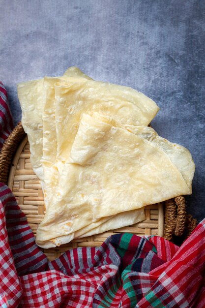 Pain plat fait maison de Roti Chapati sur une planche en bois rustique sur un fond en bois blanc