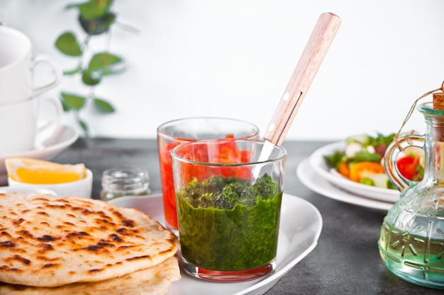 Pain plat naan indien fait maison avec salade fraîche et trempettes sur la table du dîner