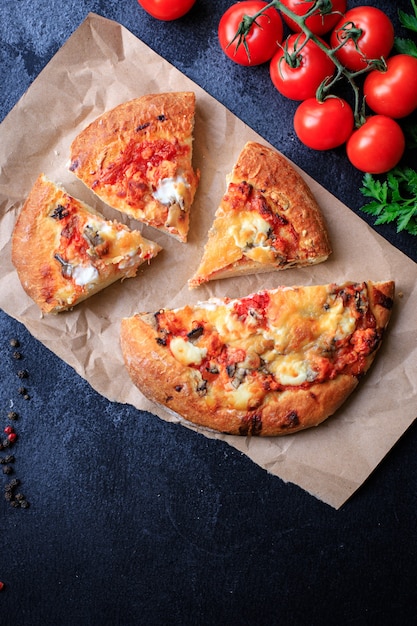Pain plat à pizza sur pâte épaisse, fromage de restauration rapide, sauce tomate, tomate et autres ingrédients