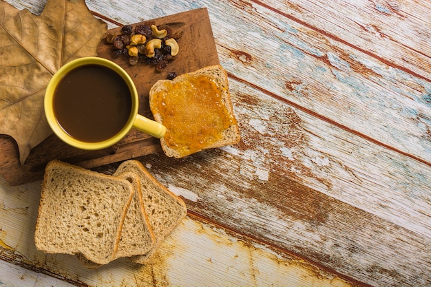 Photo pain et raisins secs près de café et de feuilles