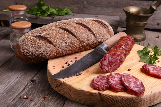 Pain de salami et un couteau sur la table de cuisine