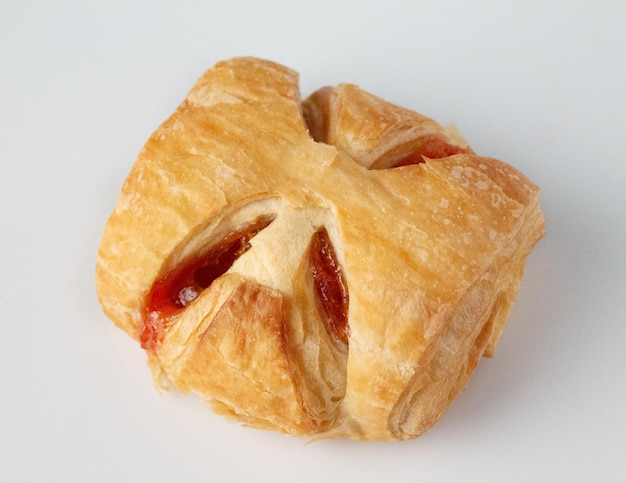 Un pain sucré avec de la confiture de baies sur un fond blanc de gâteau fait maison en gros plan