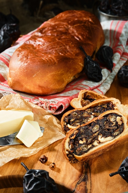 Le pain suisse aux poires ou Birnbrot est une pâtisserie locale farcie de poires séchées et de fruits. Mise au point sélective. Quartiers de muffins tranchés, beurre à côté. Photographie verticale