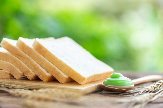 Pain sur une table en bois avec un fond clair flou vert. Concept alimentaire