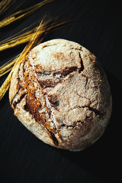 Photo pain traditionnel fraîchement cuit sur un tableau noir pain de seigle sans levure gros plan fond alimentaire