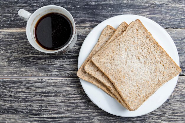 Pain tranché sur l'assiette et une tasse de café