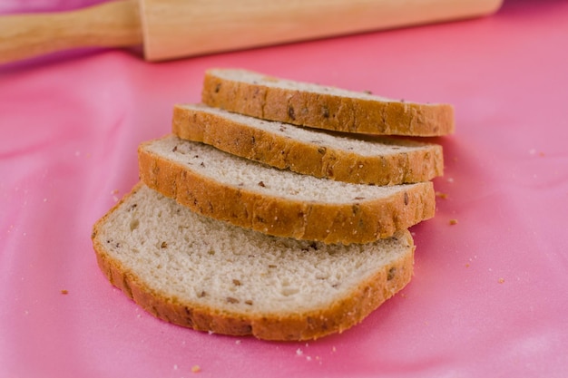 Pain tranché avec un rouleau à pâtisserie sur le tissu