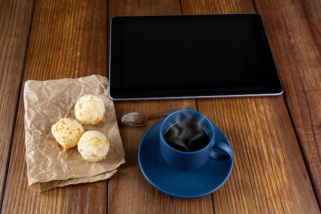 Pains au fromage brésiliens à côté d'une cuillère à café et d'une tablette en cuivre