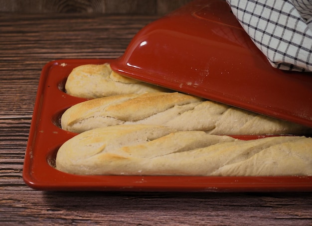 Pains baguette français frais faits maison dans un moule en porcelaine rouge