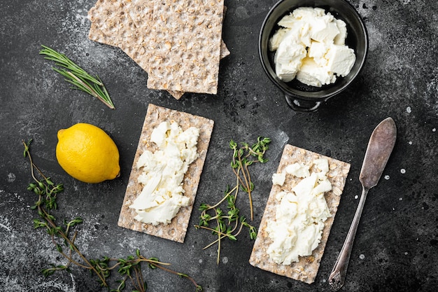 Pains croustillants avec ensemble de beurre, sur fond de table en pierre noire noire, vue de dessus à plat