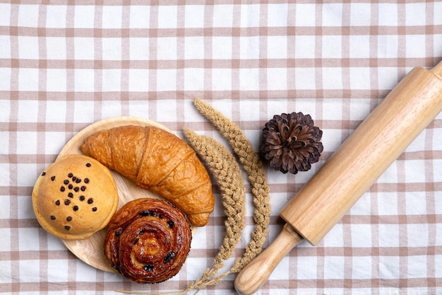 Pains faits maison ou petit pain, croissant et rouleau à pâtisserie sur blanc, concept de petit déjeuner vue de dessus et espace copie