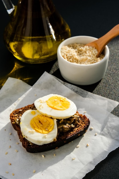 Pains grillés aux œufs durs et à l'avocat. Sandwichs au guacamole. Petit-déjeuner sain. Huile d'olive. Graines de sésame. Alimentation saine végétarienne.