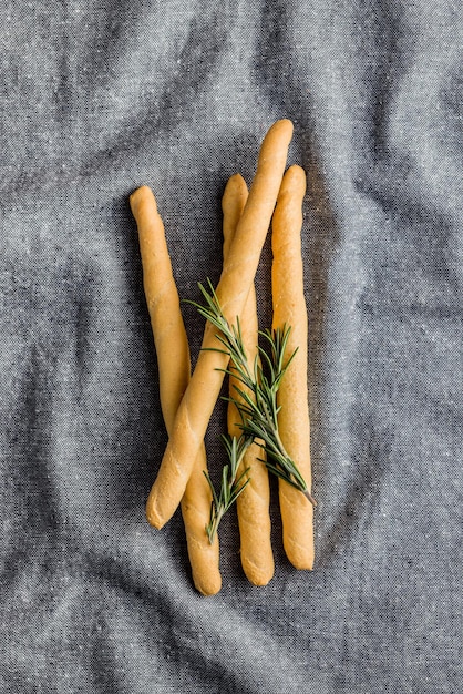 Des pains de grissini italiens et du romarin sur la nappe de la cuisine Vue supérieure