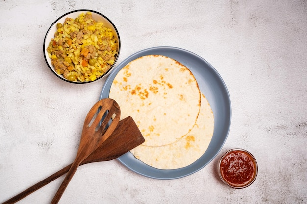 Photo pains plats mexicains et un mélange d'oignons de viande de maïs de riz pour faire des tacos et des burritos