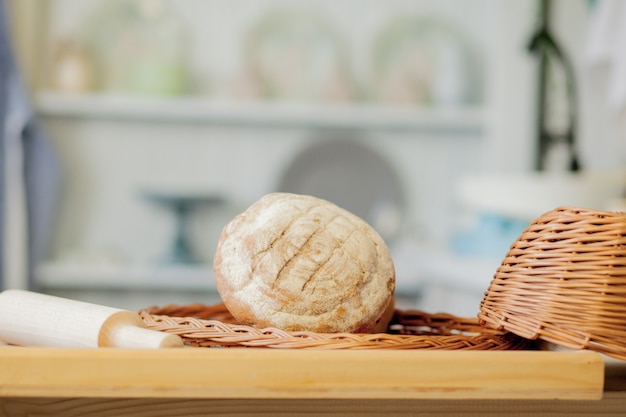 Pains près d'un panier en osier sur une table dans une cuisine rustique.