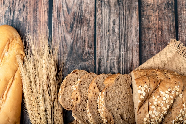 Pains tranchés et du blé sur le sac avec une table en bois