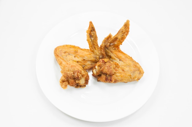 Une paire d'ailes de poulet frit sur plat blanc