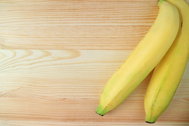 Paire de bananes mûres jaunes isolées sur une table en bois