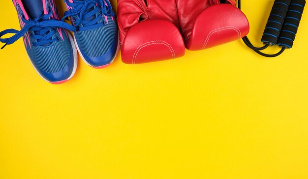Paire de baskets bleues, gants de boxe en cuir rouge