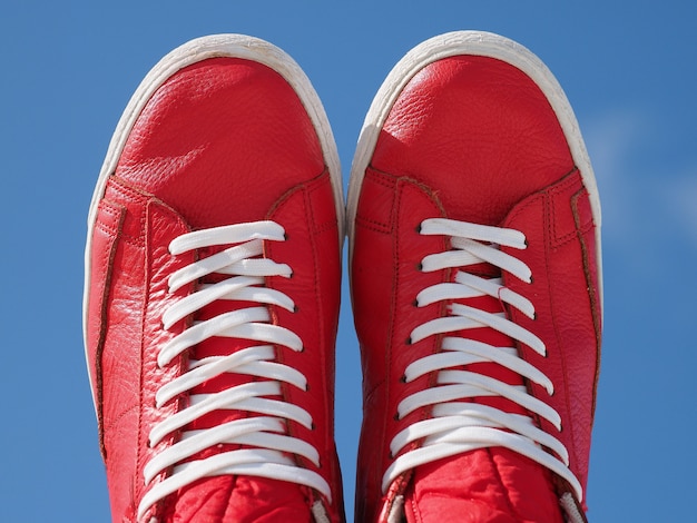 Paire de baskets rouges à lacets blancs bleu ciel.