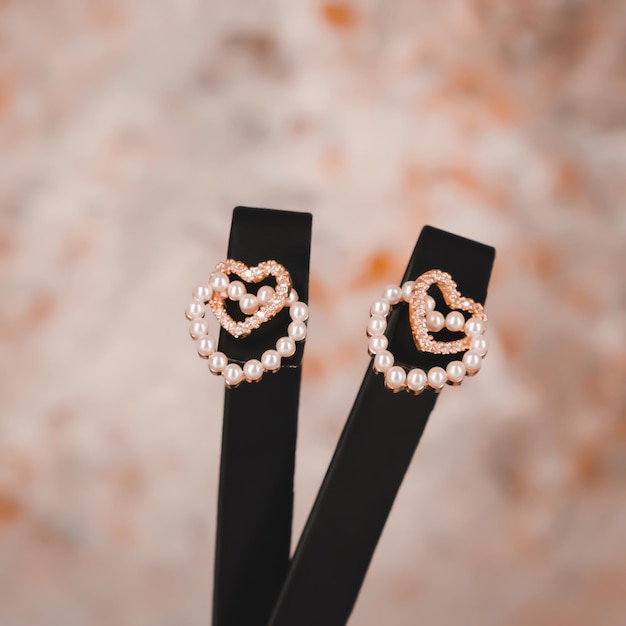 Une paire de boucles d'oreilles cœur en or avec un support noir.