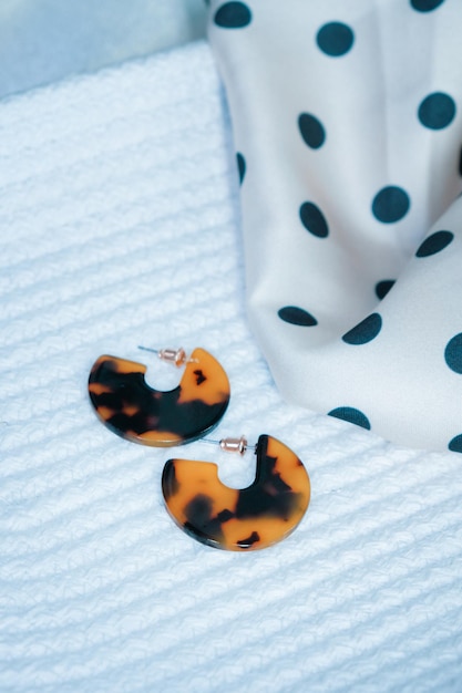 une paire de boucles d'oreilles avec un motif noir et orange.