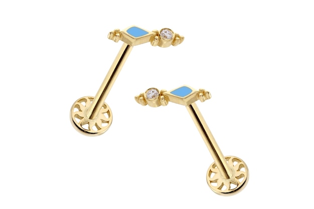 Une paire de boucles d'oreilles en or avec une pierre bleue sur le dessus.