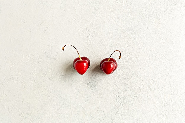 Paire de cerises laides de déformation en forme de coeur à plat sur fond blanc