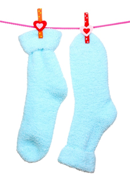 Paire de chaussettes bleues suspendues à une corde isolée sur blanc