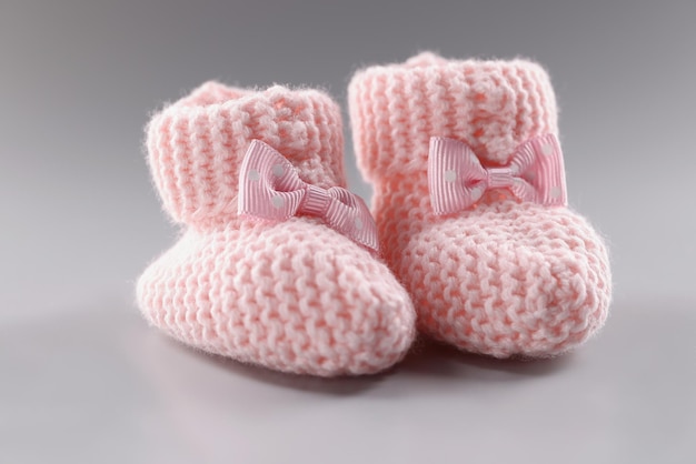 Paire de chaussons bébé roses tricotés avec un joli nœud dessus