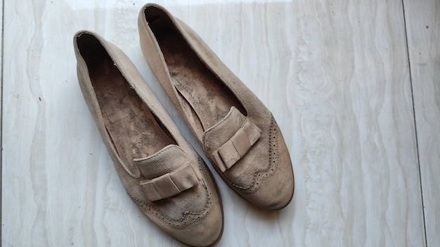 Une paire de chaussures en daim pour femmes de couleur crème qui est très poussiéreuse et sale angle photo de vue supérieure