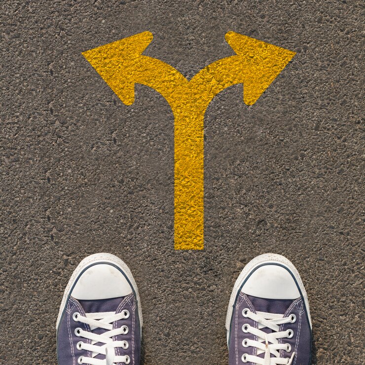 Paire de chaussures debout sur une route avec panneau de signalisation