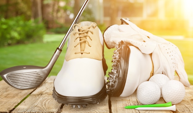 Une paire de chaussures de golf et un club de golf en arrière-plan