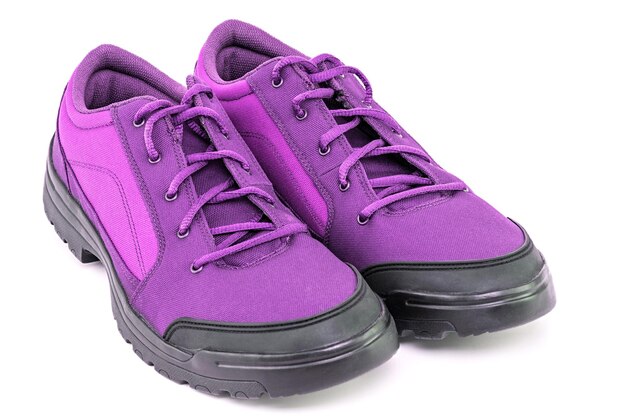 Une paire de chaussures de randonnée violet bon marché simple isolé sur fond blanc perspective vue rapprochée