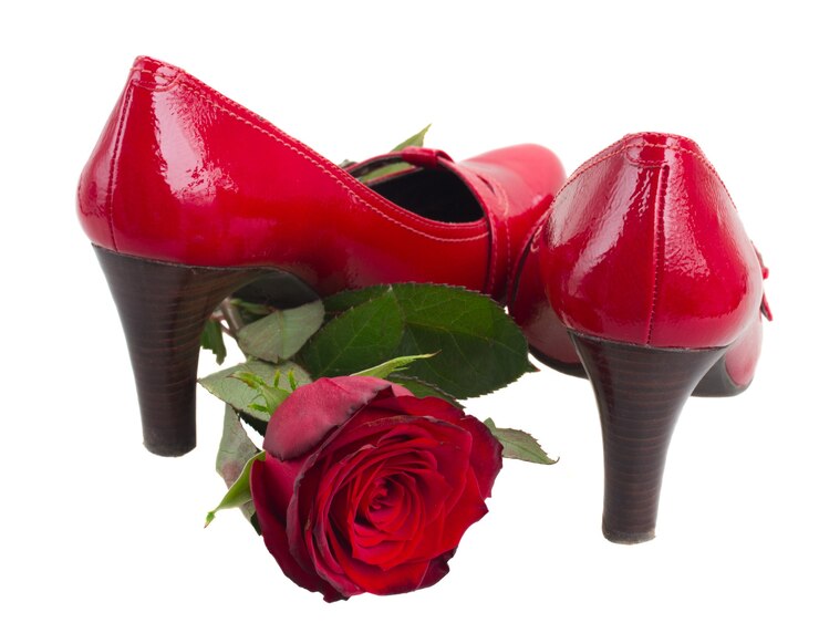 Photo paire de chaussures rouges avec fleur rose isolé sur fond blanc