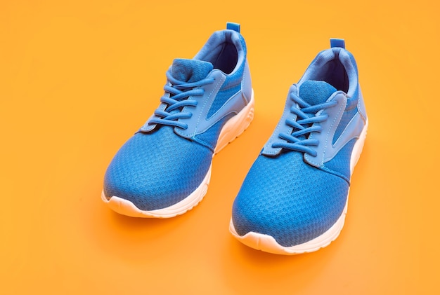 Paire de chaussures de sport bleues confortables sur des chaussures à fond jaune