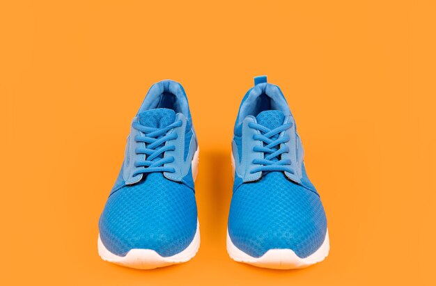 une paire de chaussures de sport bleues confortables sur un fond jaune