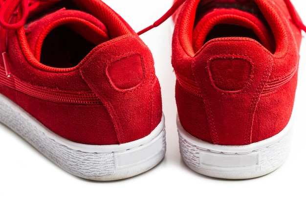 Une paire de chaussures en toile rouge sur fond blanc