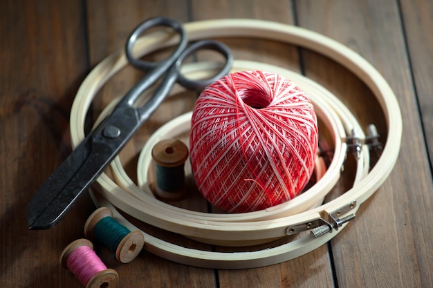 Une paire de ciseaux, une balle rouge et une paire de ciseaux sont assis sur une table en bois.