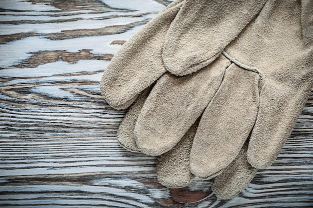 Paire de gants de sécurité en cuir sur planche de bois