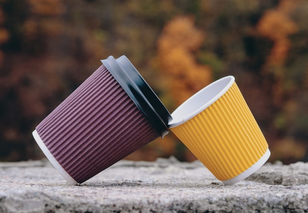 Une paire de gobelets en papier marron et jaune, à emporter, du café à emporter.