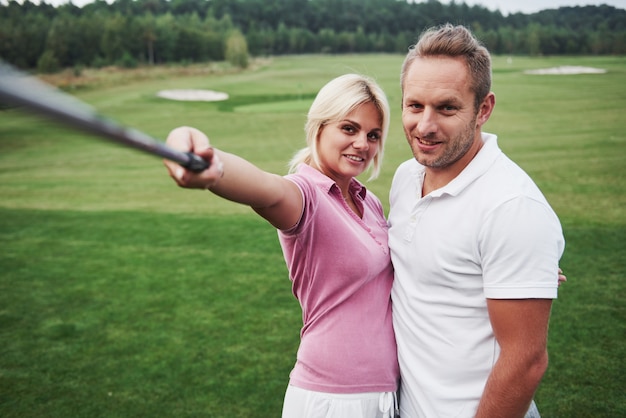 Une paire de golfeurs fait une photo sur le terrain de golf à l'aide d'un bâton comme un bâton sephi