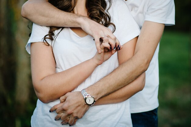 Paire de jeunes amants, main dans la main sur fond de nature. vue du couple debout, les femmes et les hommes. moitié supérieure. Fermer.