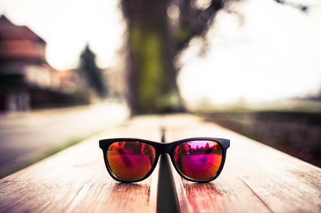 Photo une paire de lunettes de soleil sur un banc en bois avec le mot lunettes de soleil dessus.